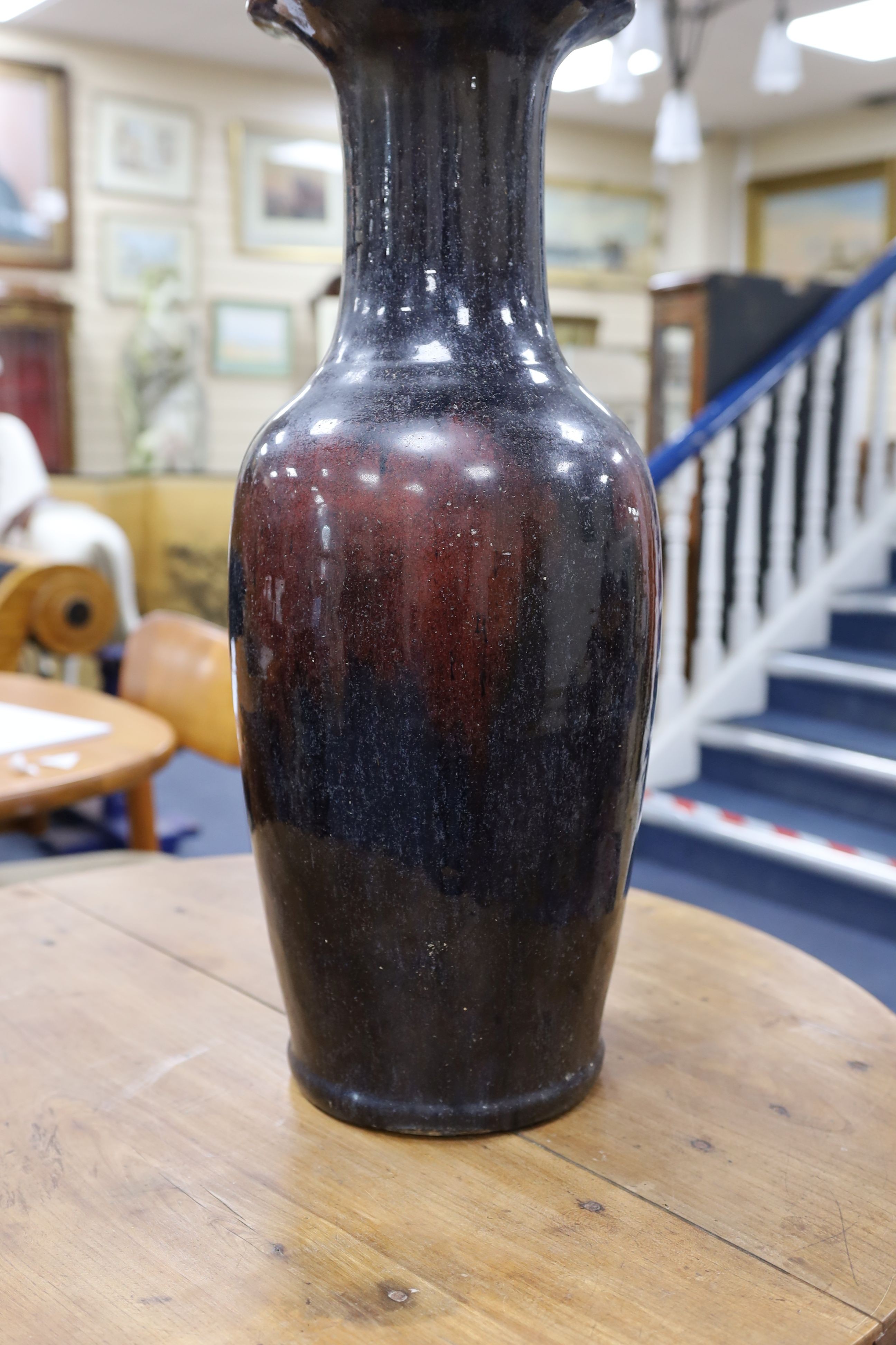 A large Chinese sang de boeuf glazed vase on carved wooden stand., Vase 61 cms high not including stand.